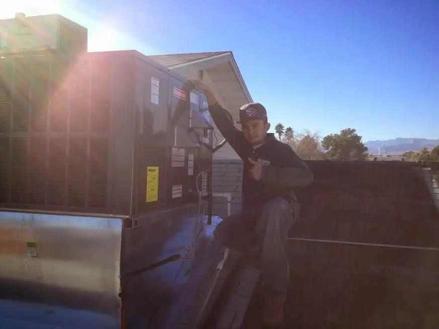 HVAC technician performing AC Tune-Up on a rooftop unit in Mountain View